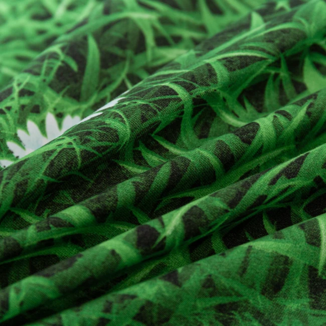 detal-nadruku-bialych-stokrotek-na-zielonym-mikrowloknie