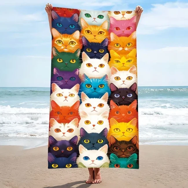Ręcznik plażowy z mikrofibry 100x180 cm z gęstym wzorem kolorowych, bajkowych kocich pyszczków.